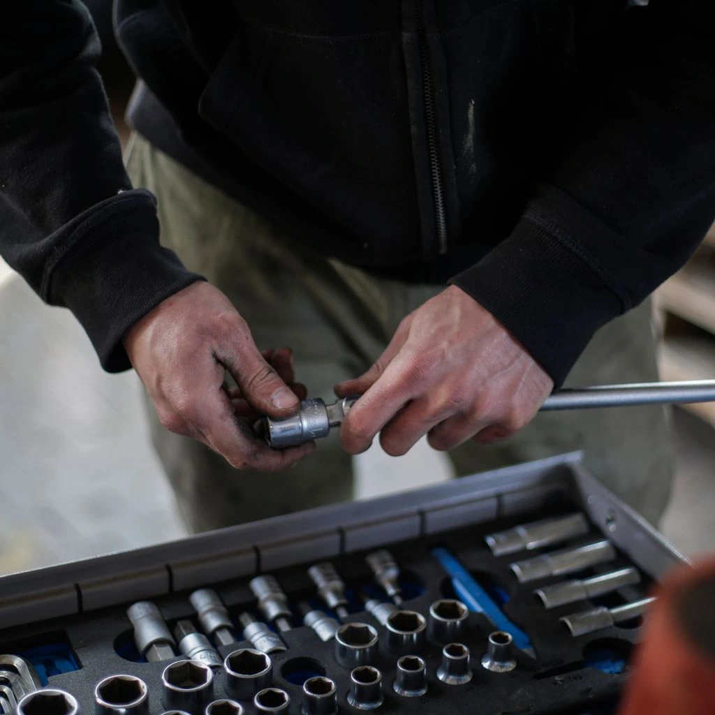A worn steel service counter bench where a broken tool is logged in for warranty repair.