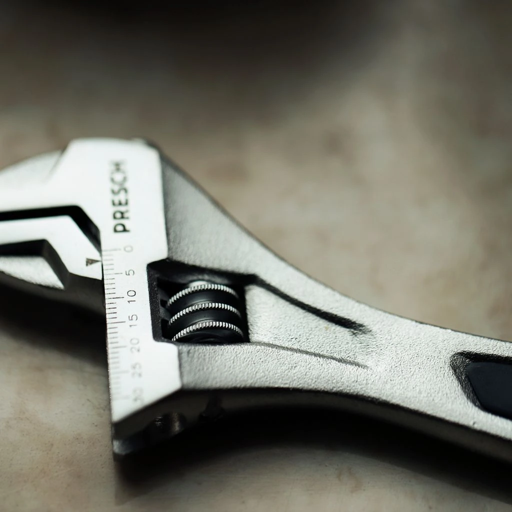 A replacement wrench being handed across the counter with a stamped warranty card.
